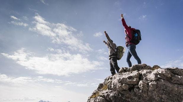 People shouting from the peak of a mountain