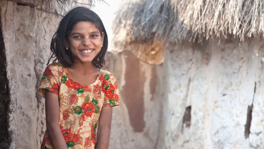 Child smiling in front of building