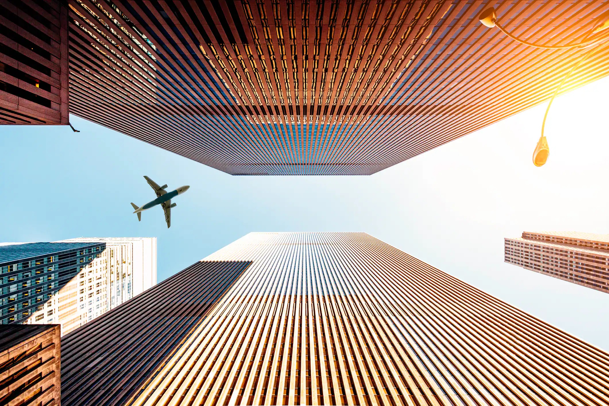 plane flying in between two skyscrapers