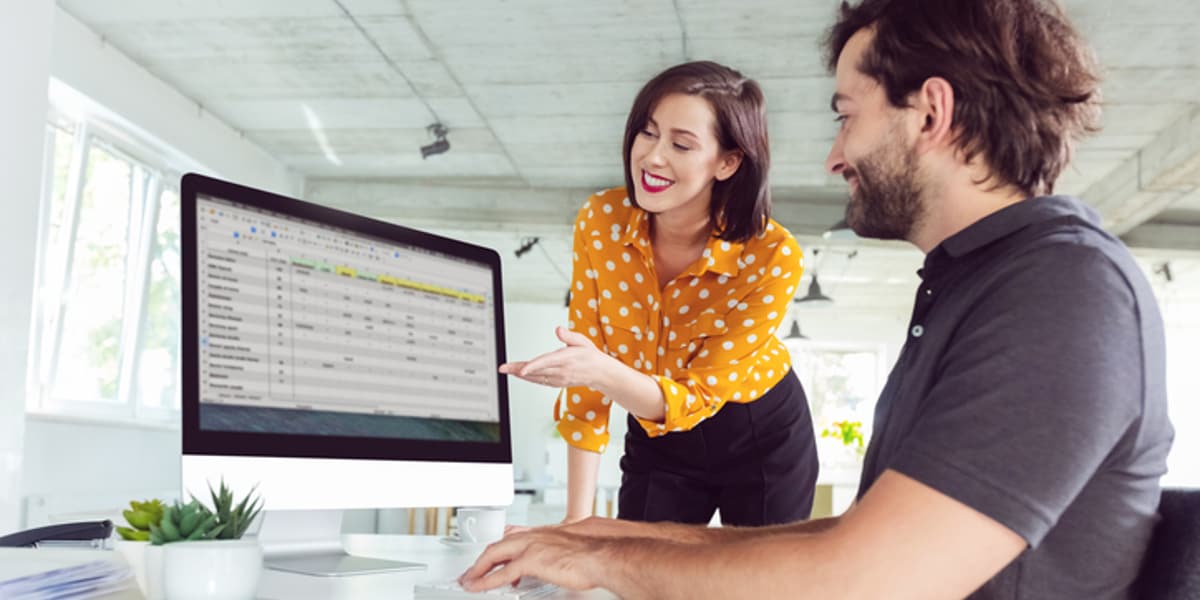 man and woman working on computer together