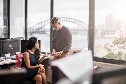 woman and man using our buyer's guide at their office desks in an Australian office