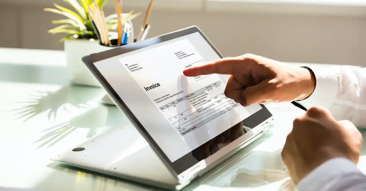 finger pointing at tablet device showing an invoice on the screen
