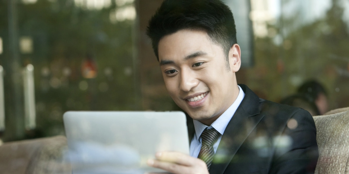 man smiling looking at tablet
