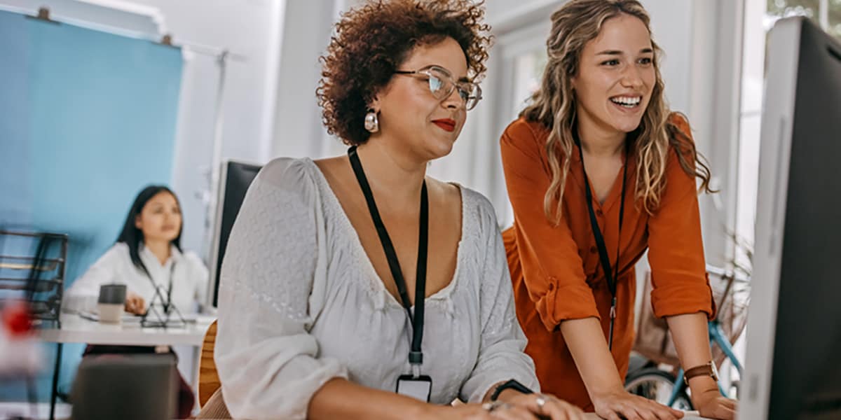 two employees working together at desk