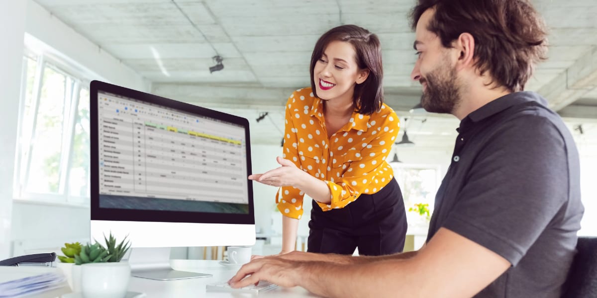 two people working on computer at office desk