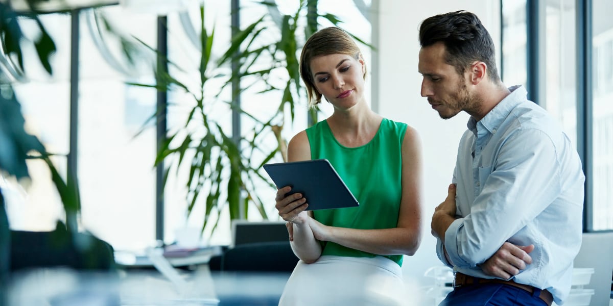 two colleagues looking at tablet in office