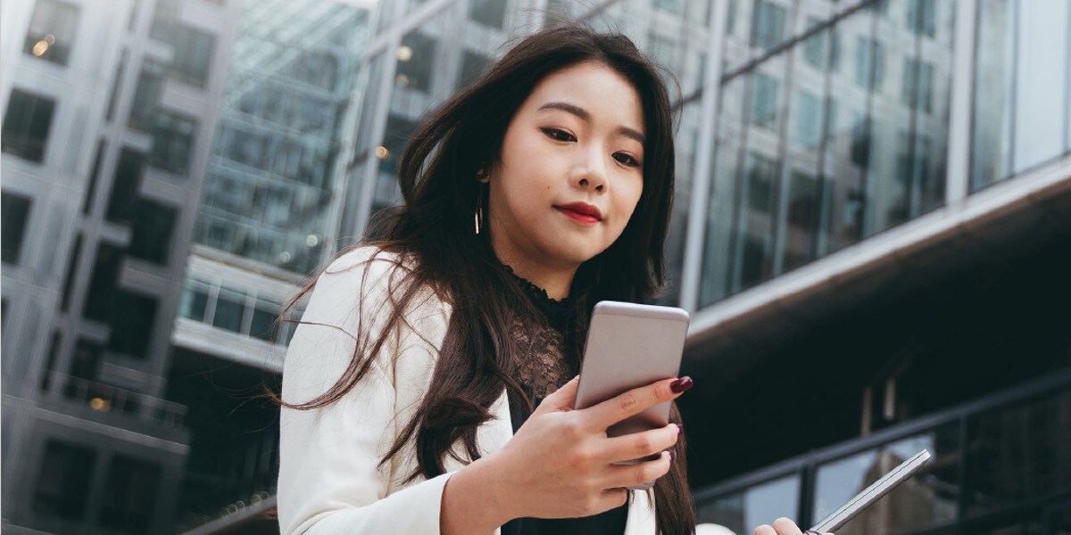 woman looking down at mobile device