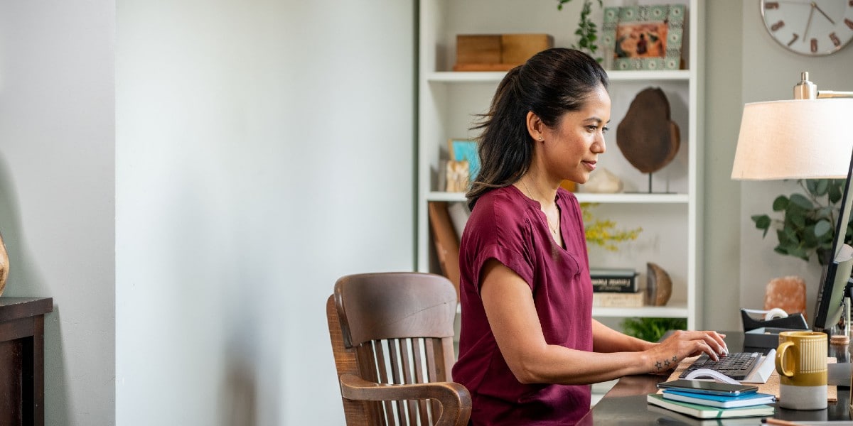 woman sitting at hone desk working on laptop