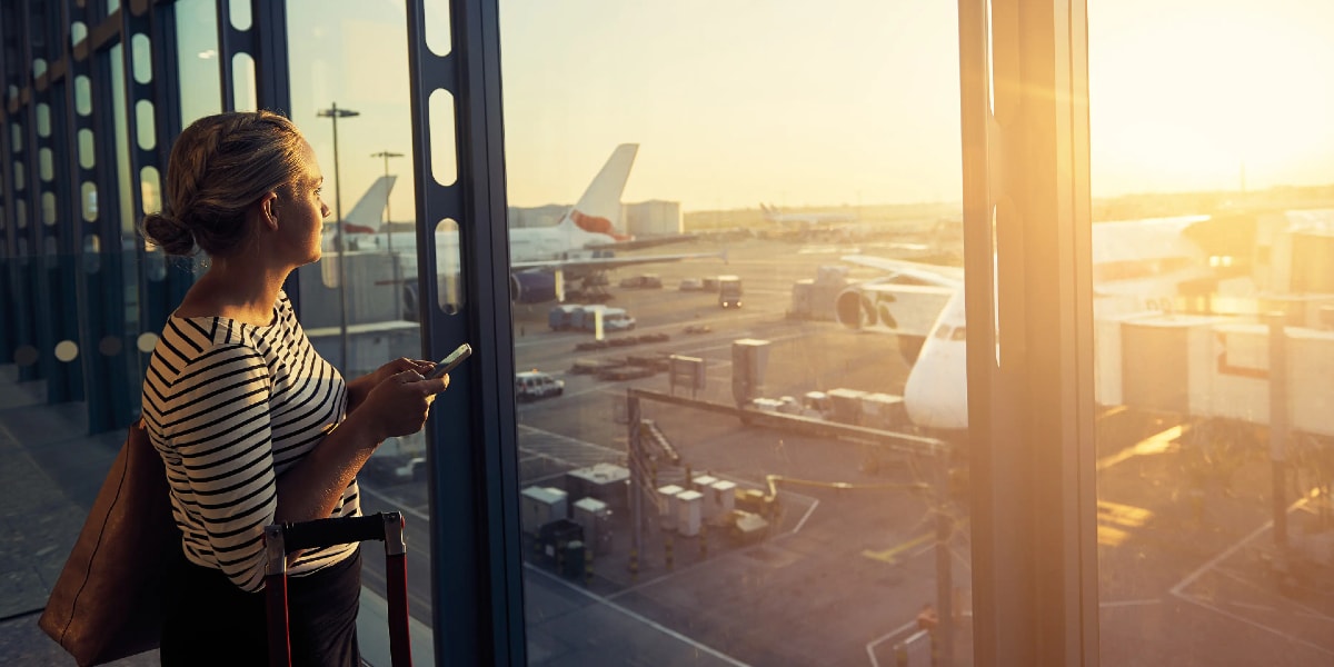 woman in airport looking out to airplanes